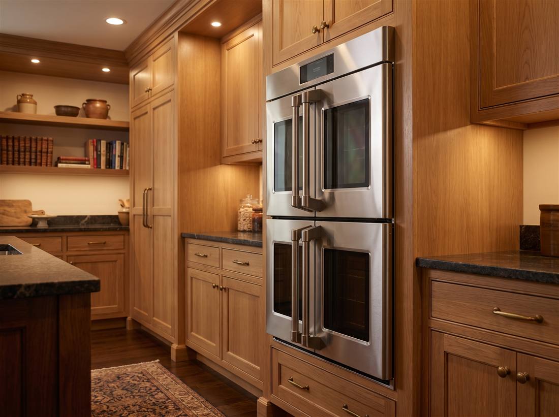 Double wall ovens with French doors in green cabinetry
