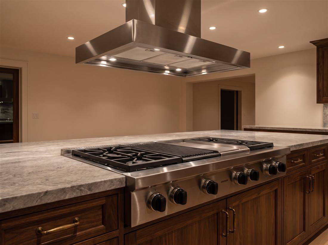 Professional stainless rangetop with grill and griddle under a large hood